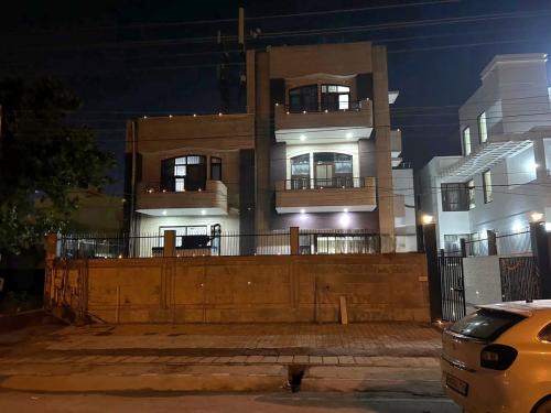a building with a fence in front of it at night at RAJ RESIDENCY in Gurgaon