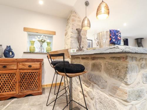 a kitchen with a stone counter and a stool at La Petit Maison in Saint Columb Major