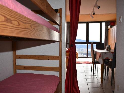 a bedroom with a bunk bed and a dining room with a table at Studio Font-Romeu-Odeillo-Via, 1 pièce, 4 personnes - FR-1-580-86 in Font-Romeu-Odeillo-Via