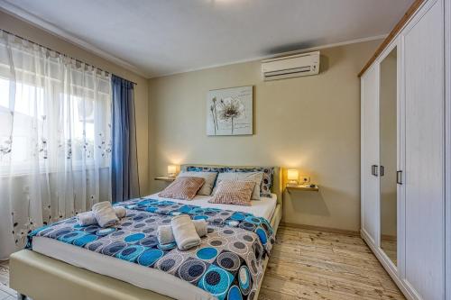 a bedroom with a bed with pillows and a window at Villa Agri with large Garden and Pool near Pula in Loborika