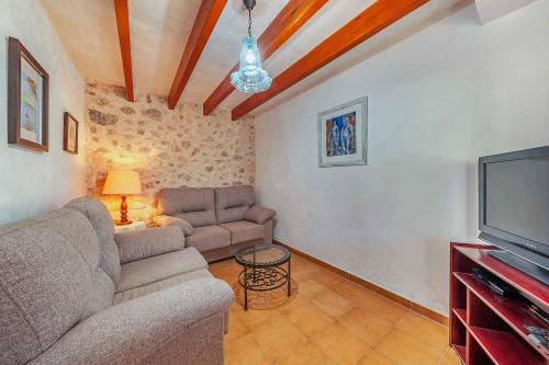 a living room with a couch and a tv at Can Plaseta in Pollença