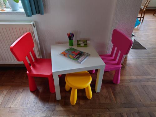 Hotel Schützenhaus Lenzen في Lenzen: طاولة مع كرسيين وطاولة مع كتاب