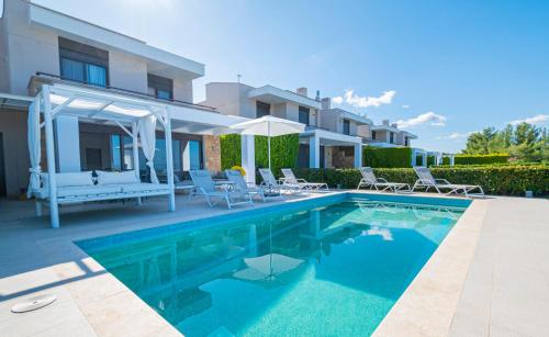 a swimming pool in front of a house at Bellevue Villas with private pool in Hanioti