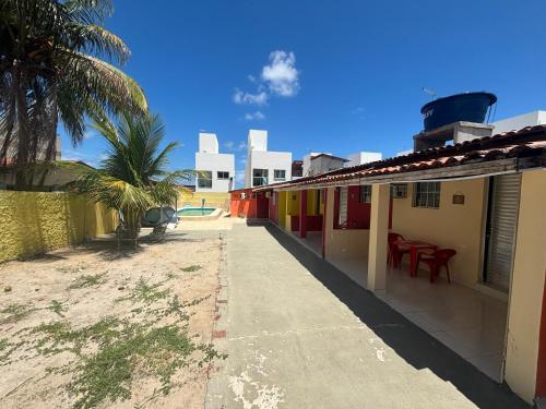 un trottoir à côté d'une maison avec un palmier dans l'établissement Hostel e Pousada Jacumã, à Conde