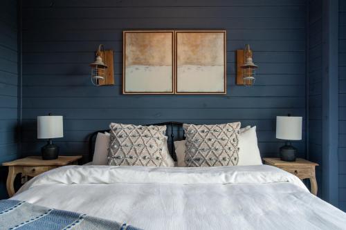 a blue bedroom with a bed and two lamps at Chalet Amelia Lake View HotTub Fireplace Arcade in Dandridge