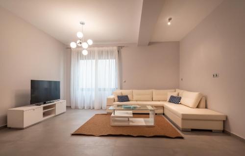 a living room with a couch and a tv at Bellevue Villas with private pool in Hanioti