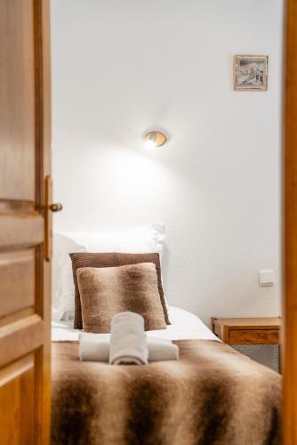 a bedroom with a bed with a pillow and a light at Logis Hôtel et Spa Le Christiania in La Salle Les Alpes