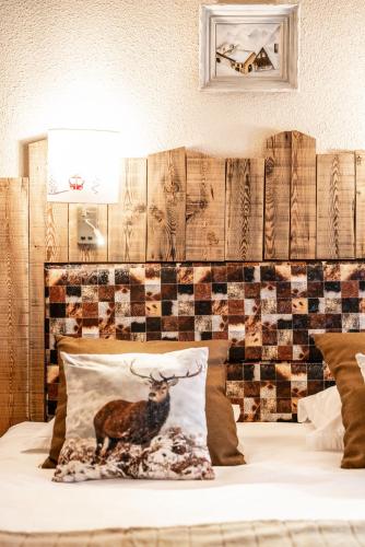 a bed with a pillow with a deer on it at Logis Hôtel et Spa Le Christiania in La Salle Les Alpes