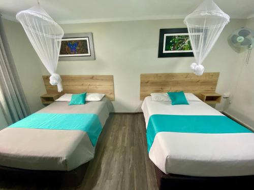 two beds in a room with blue and white at Casa Plaza Bolívar in Quillabamba