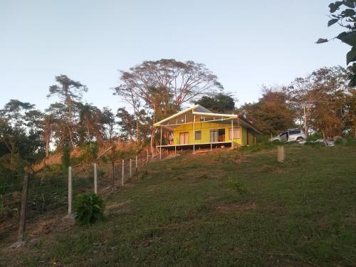 une maison jaune assise au sommet d'une colline dans l'établissement Villa, KOCORU Casa de campo y playa, à Puntarenas