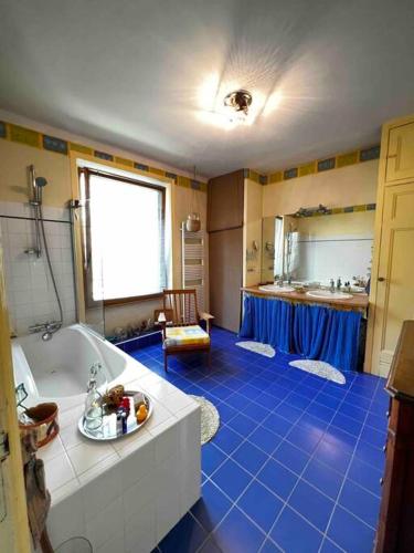 baño con bañera y suelo de baldosa azul en Maison Familiale avec Jardin !, en Lanester