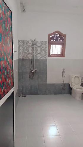 baño con aseo y ventana en Sunrise Relax Inn en Beruwala