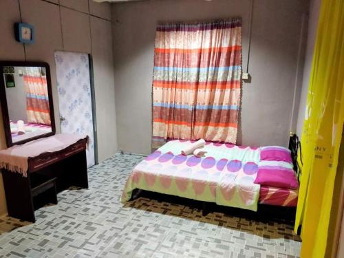 a bedroom with a bed and a mirror and a dresser at LD SWEET HOMESTAY LAHAD DATU in Lahad Datu
