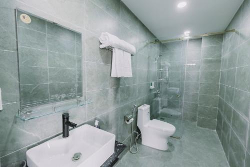 a bathroom with a toilet and a sink and a shower at Arina Luxury Hotel - Vincom Tay Ninh in Tây Ninh