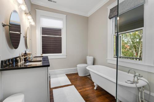 a white bathroom with a tub and a sink at Simmons Whimsical Historic Home in Wilmington