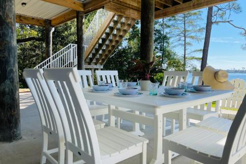 Biały stół i krzesła na ganku w obiekcie Holley Point Holiday House w mieście Navarre
