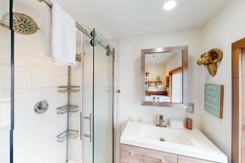 een badkamer met een wastafel en een douche bij Hummingbird Hideout in Port Orford
