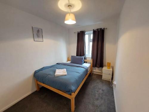 sypialnia z łóżkiem z niebieską pościelą i oknem w obiekcie 3 bedroom Flat in Hoxton London w Londynie