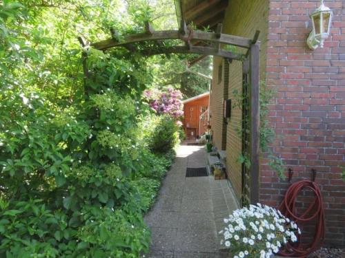 - l'entrée d'un bâtiment en briques avec une arche et des fleurs dans l'établissement Ferienwohnung Kiebitznest, à Sehestedt