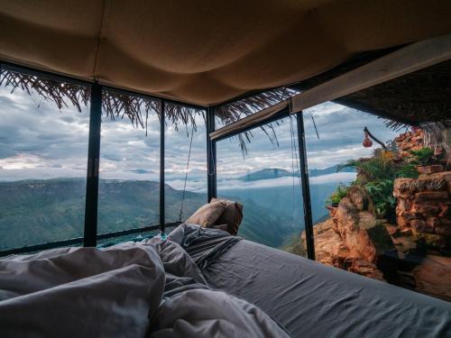 a bed in a room with a view of a mountain at REFUGIO LA ROCA in Los Santos