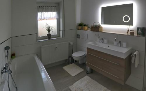 ein Badezimmer mit einem Waschbecken, einer Badewanne und einem WC in der Unterkunft Apartment Am Mittelpunkt Deutschlands in Niederdorla