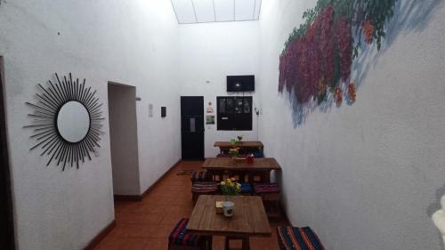 Habitación con mesas y espejo en la pared. en Hotel Posada Don Papagon, en Antigua Guatemala