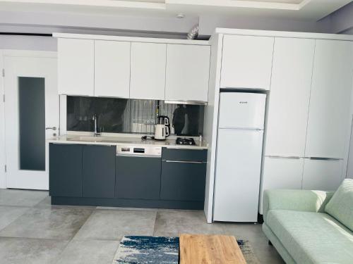a kitchen with white cabinets and a white refrigerator at Apart Angel Suit 5 in Nevsehir