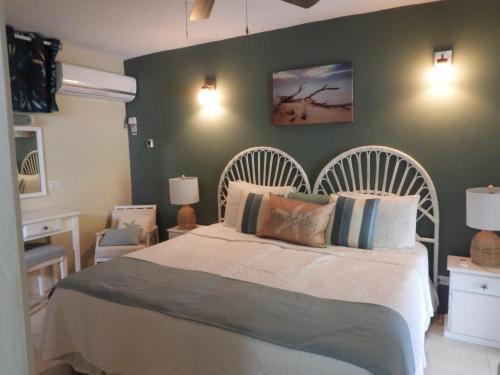 um quarto com uma cama e uma parede verde em Golden View Apartment em Saint James