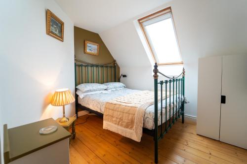 ディングルにあるBrosnan's Cottageのベッドルーム(ベッド1台、窓付)