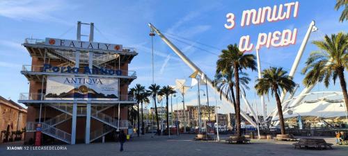 a building with a sign and palm trees in a city at La Brignoletta Le Case del Dria Acquario suite in Genova