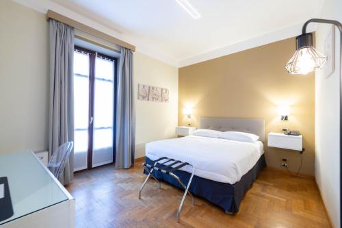 um quarto de hotel com uma cama e uma janela em Hotel La Fertè em Asti