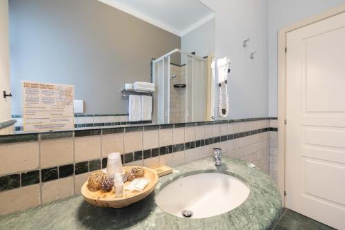 La salle de bains est pourvue d'un lavabo et d'un miroir. dans l'établissement Hotel La Fertè, à Asti