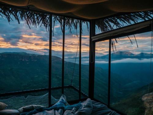 a room with a bed and a view of the mountains at REFUGIO LA ROCA in Los Santos
