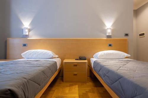 two beds sitting next to each other in a room at Hotel La Fertè in Asti