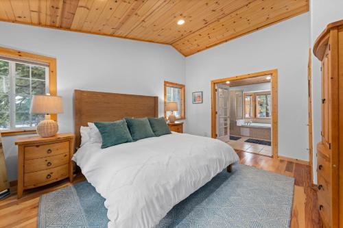 una camera da letto con un letto grande e un soffitto in legno di Tahoe Grand on the West Shore - Pet Friendly & Hot Tub! a Homewood