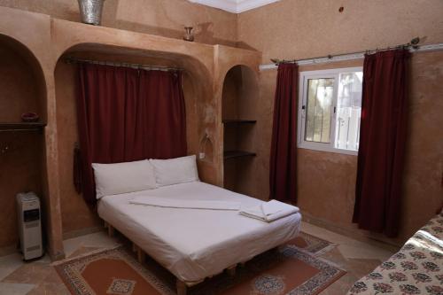 Cama pequeña en habitación con ventana en CHEZ MANAR, en Ouarzazate
