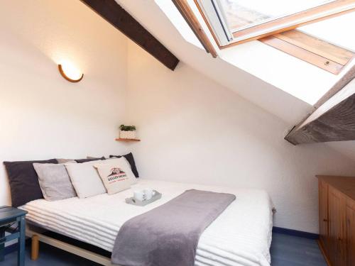une petite chambre avec un lit dans un grenier dans l'établissement Charmant T2 pour 4 pers. avec balcon et casier à skis, Saint-Lary Village, proche navette gratuite - FR-1-296-479, à Saint-Lary-Soulan