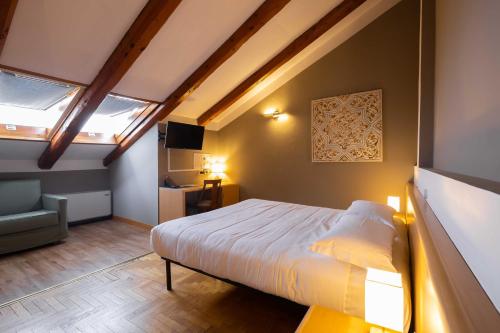 a bedroom with a bed in a room with skylights at Hotel La Fertè in Asti