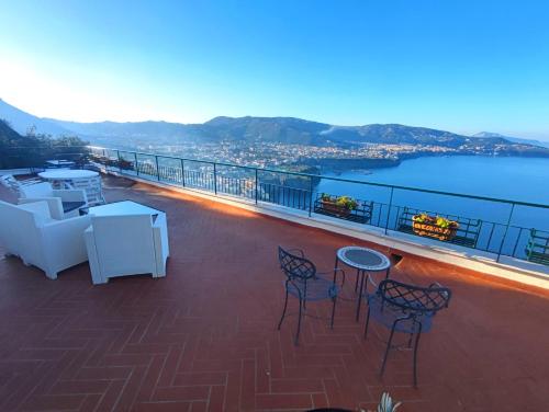 a balcony with chairs and tables and a view of the water at Giardino 21 Marzo in Vico Equense