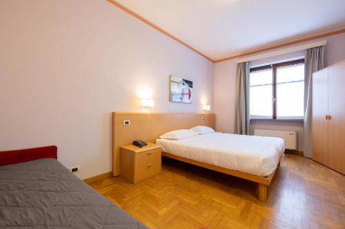 a hotel room with two beds and a window at Hotel La Fertè in Asti