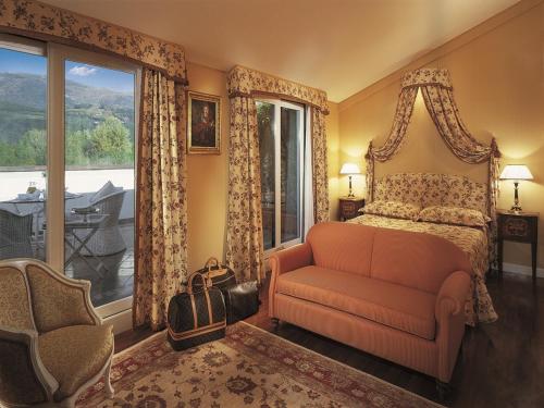 a bedroom with a bed and a couch and a window at Versilia Golf Resort in Forte dei Marmi