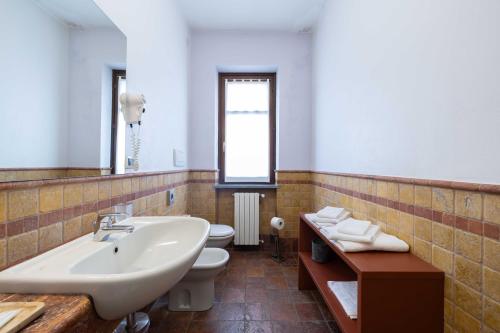 a bathroom with a white sink and a toilet at Hotel La Fertè in Asti