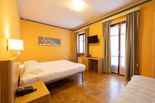 a hotel room with two beds and a television at Hotel La Fertè in Asti