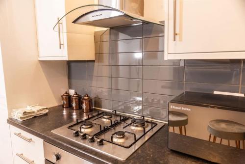 a kitchen with a stove top oven in a kitchen at 3-Bed Apartment Central London - 15 Mins walk to Kings Cross by Seren Short Stays in London