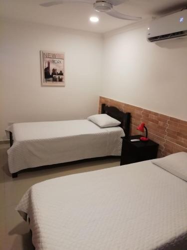 Habitación de hotel con 2 camas y una foto en la pared en Apto amoblado barrio Los Alpes Cartagena en Cartagena de Indias
