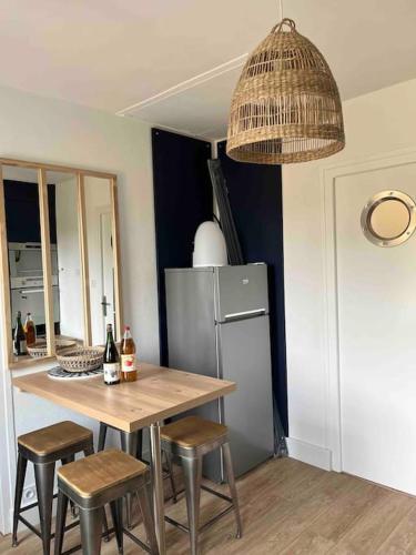 une cuisine avec une table, des chaises et un réfrigérateur dans l'établissement Ty glaz, à Ploubazlanec