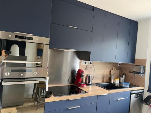 a kitchen with blue cabinets and a counter top at Ty glaz in Ploubazlanec