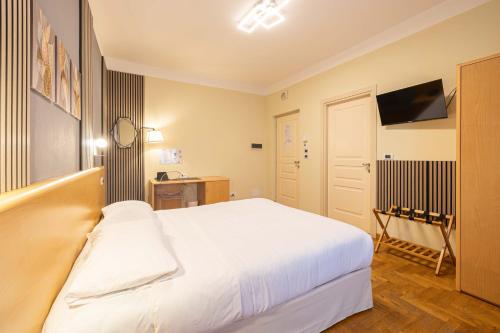 a bedroom with a white bed and a television at Hotel La Fertè in Asti