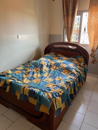 Una cama con edredón en una habitación en loft moderne, en Yaoundé