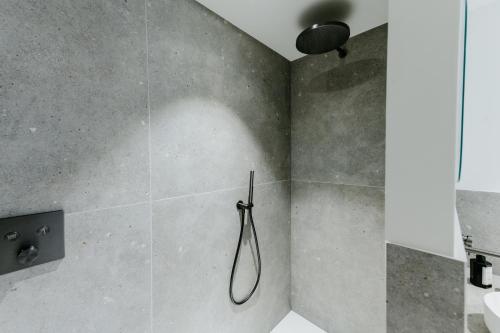 a shower in a bathroom with a hose on the wall at Cathedral view from the bathtub in Antwerp